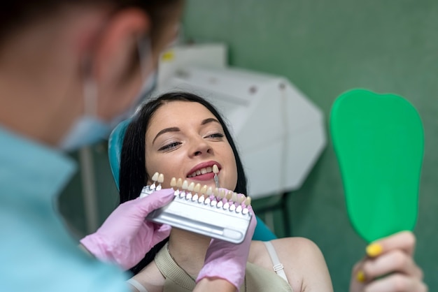 Il paziente in odontoiatria ha scelto il colore dei denti dal campionatore