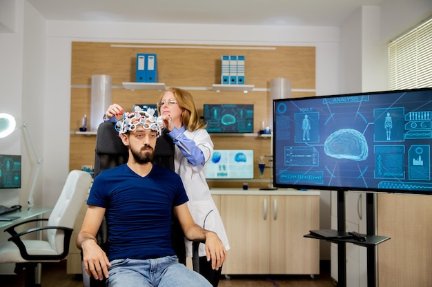 Patiënt die een hersenscanprocedure ondergaat in een neurologisch centrum. Neurologie scanning headset