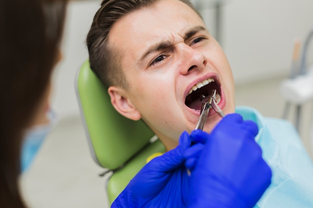 Foto patiënt die pijn ervaart bij de tandarts