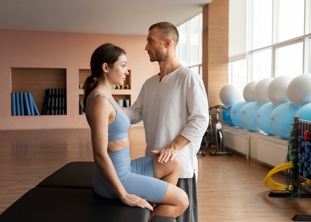 Photo patient doing physical rehabilitation helped by therapists