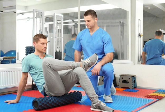 Patient exercising under physiotherapist supervision in rehabilitation center