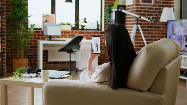 Patient getting virtual consultation through telehealth program\
while talking with doctor on online videocall on mobile phone.\
woman discussing with general practitioner on computer digital\
call.