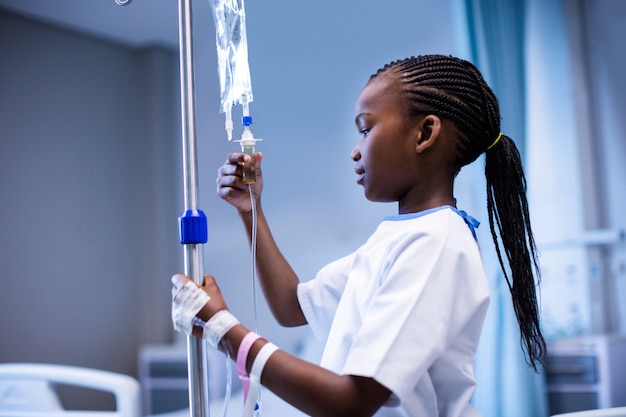 Patient holding IV stand at hospital