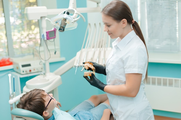 Patiënt in tandartsstoel Tienerjongen met tandheelkundige behandeling op het kantoor van tandartsen