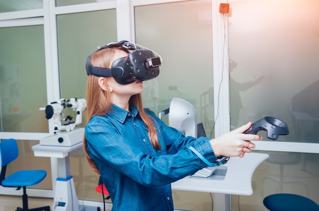 Patiënt in virtual reality-bril. De visie van het meisje controleren met behulp van virtual reality.