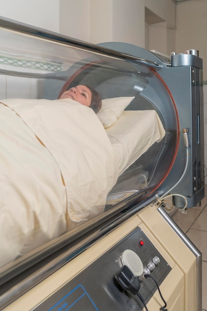 Patient lying inside a hyperbaric treatment machine