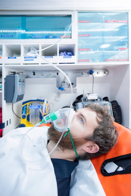 Patient lying on stretcher with oxygen mask