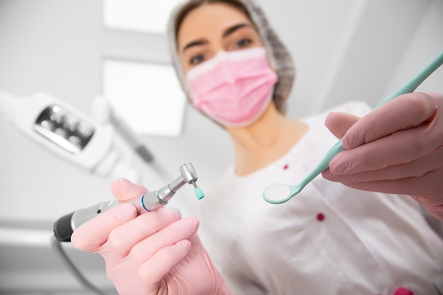 The patient's first-person view at the examination by the dentist lies in the dental chair. Doctor Dental surgeon examines an oral cavity with the help of somatological tools.