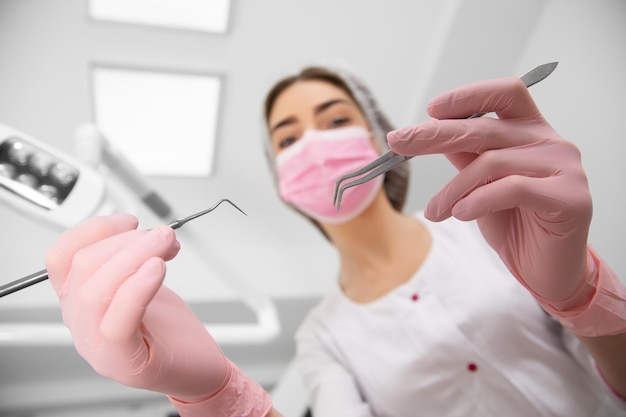 La visuale in prima persona del paziente all'esame del dentista si trova sulla poltrona del dentista. il medico chirurgo dentale esamina una cavità orale con l'aiuto di strumenti somatologici.