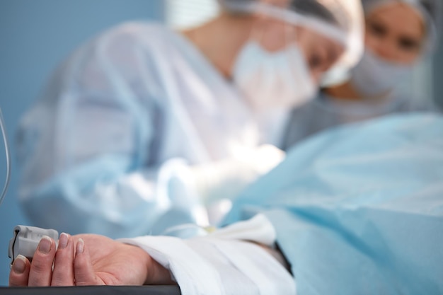 The patient's hand is under the IV with a pulse oximeter on the finger Medical services