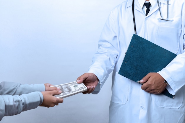 Patient's hand paying a money to doctor