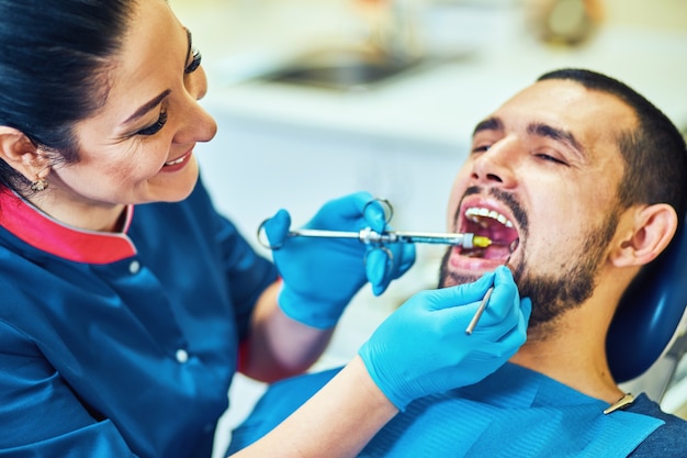 치아를 뽑기 전에 마취를 받을 준비를 하는 치과 의자에 앉아 있는 환자.