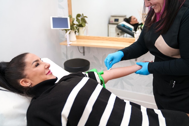 Photo patient smiling during the blood draw for hair therapy