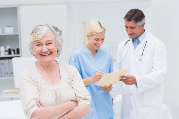 의사와 간호사가 병원에서 논의하는 동안 웃는 환자