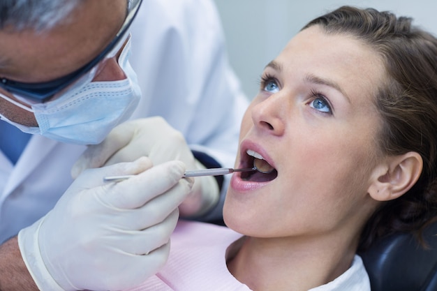 Patient teeth being examined with angle mirror