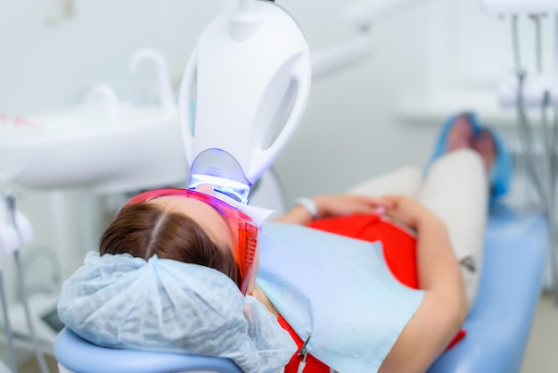 The patient undergoes a procedure for teeth whitening with an ultraviolet lamp