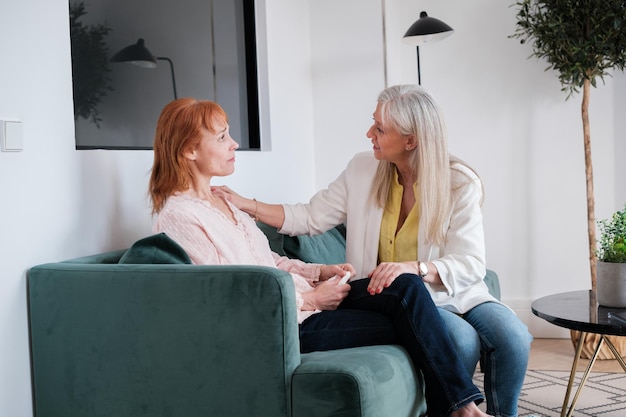 Patient with depression being comforted and supported by her psychologist in therapy