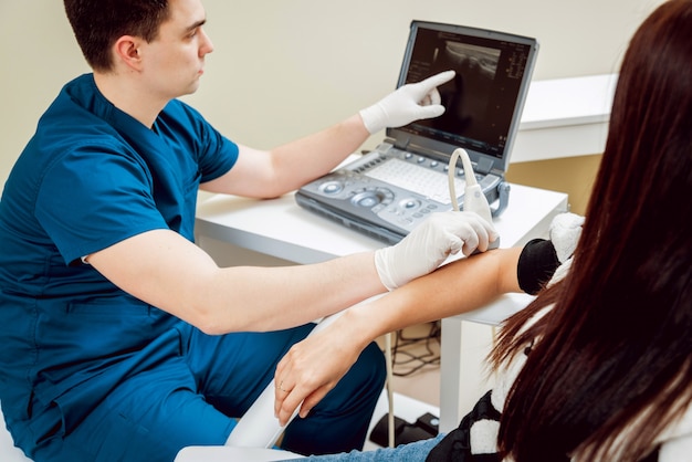 Photo patient with orthopedist doctor in his office.