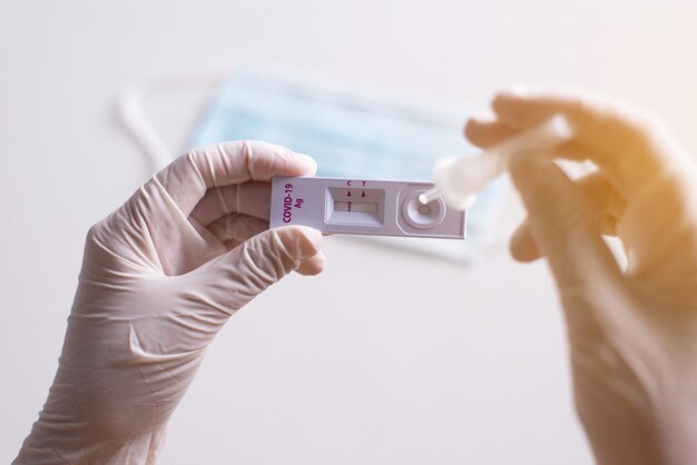 Patient women hands showing result a covid-19 self test rapid antigen testing at home