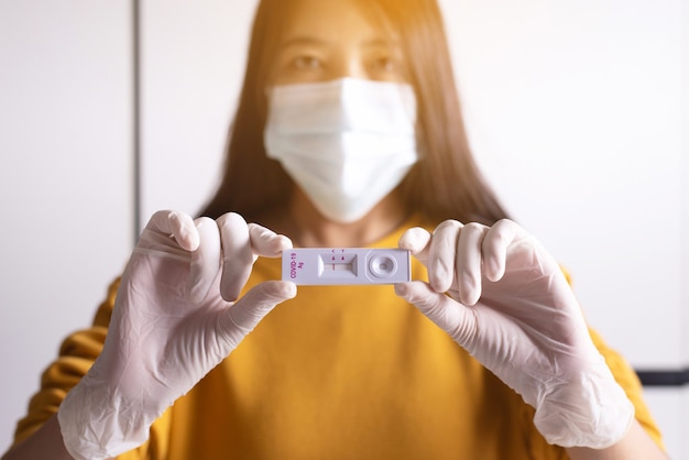 Patient women hands showing result a covid-19 self test rapid antigen testing at home