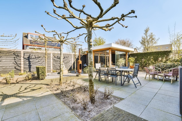 A patio with a tree and tables and chairs