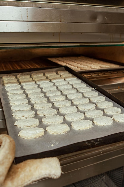 Patissier zet dacquoise beslag koekjeskoekje voor bakken in de oven in een traditionele Europese bakker