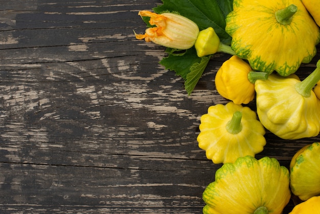 Patisson, Squash, dish-shaped pumpkin, raw vegetable on a dark wooden background