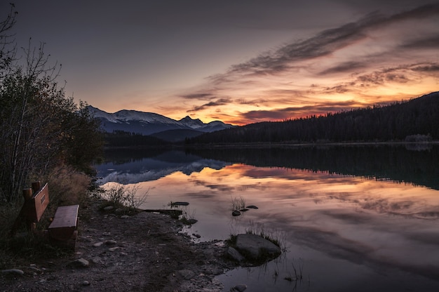 カナダ、ジャスパー国立公園の山脈と夕焼け空のあるパトリシア湖