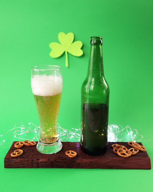 patrick day fresh foamy beer in a glass chips and crackers on a wooden board shamrock