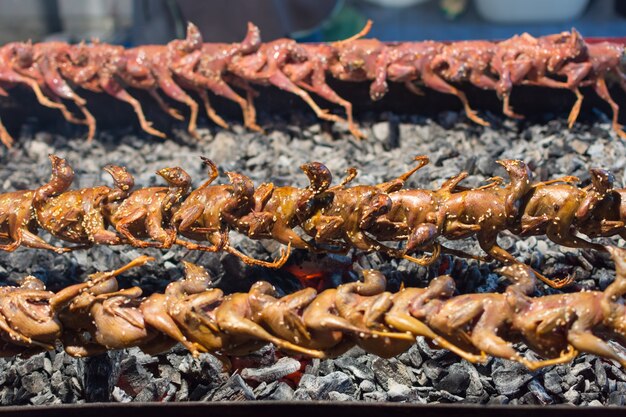 Patrijs of kwartel gegrild op een houtskool is een barbecue voedsel van vogel verkopen in Thais straatvoedsel