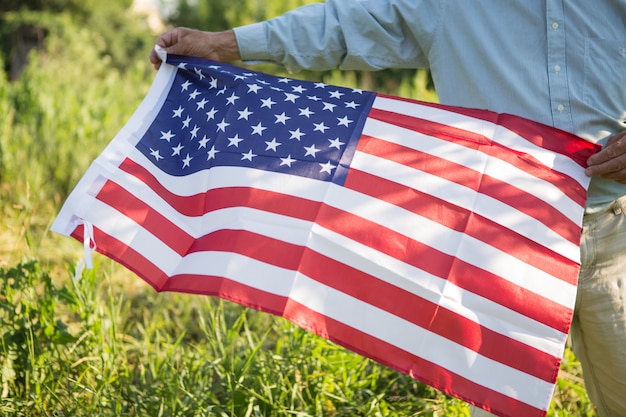 アメリカの国旗を持つ愛国心が強い年配の男性