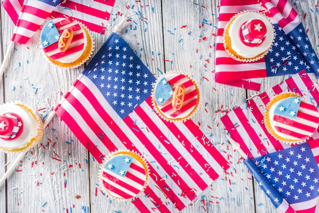 Patriotic USA cupcakes over flags on wood table