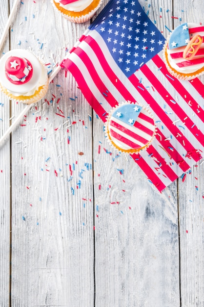 Patriotic USA cupcakes over flags on wood table