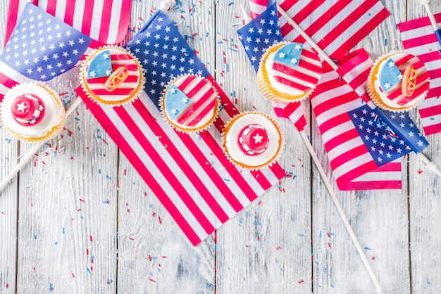 Patriotic USA cupcakes over flags on wood table