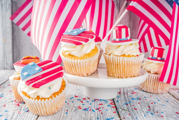 Patriotic USA cupcakes over flags on wood table