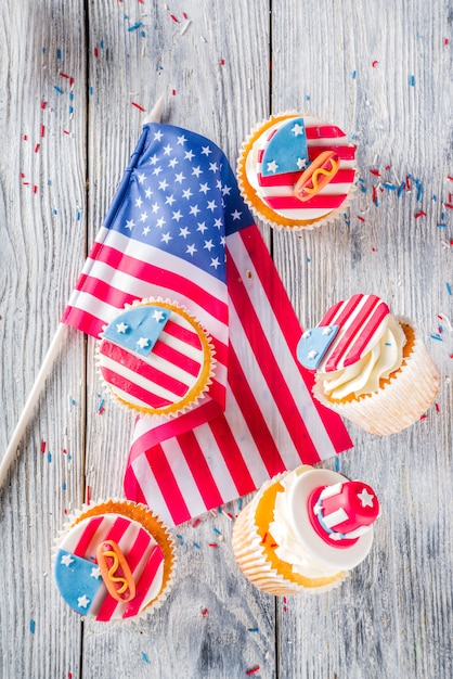 木のテーブル上のフラグの上の愛国心が強いアメリカのカップケーキ