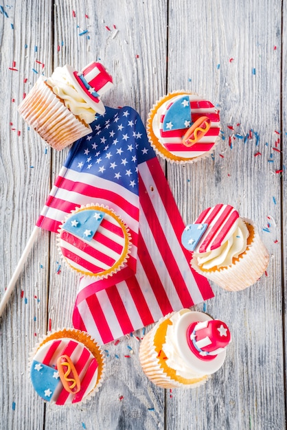 Patriotic USA cupcakes over flags on wood table