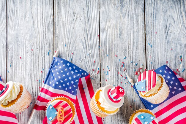 Patriotic USA cupcakes over flags on wood table