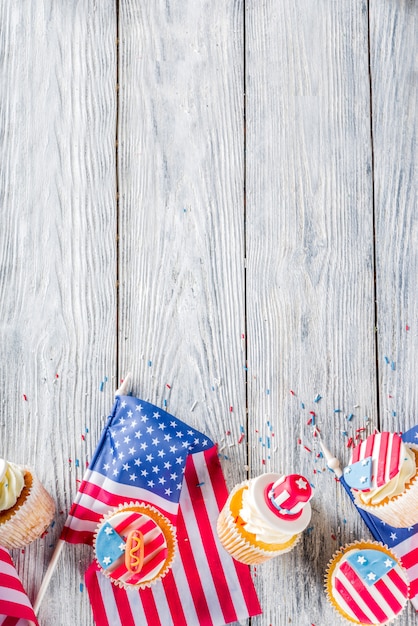 木のテーブル上のフラグの上の愛国心が強いアメリカのカップケーキ