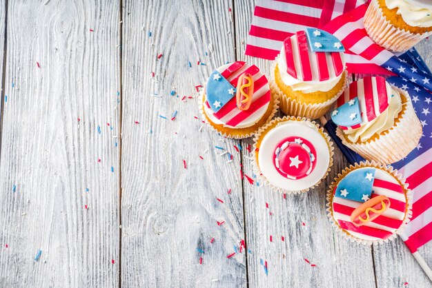 Patriotic USA cupcakes over flags on wood table