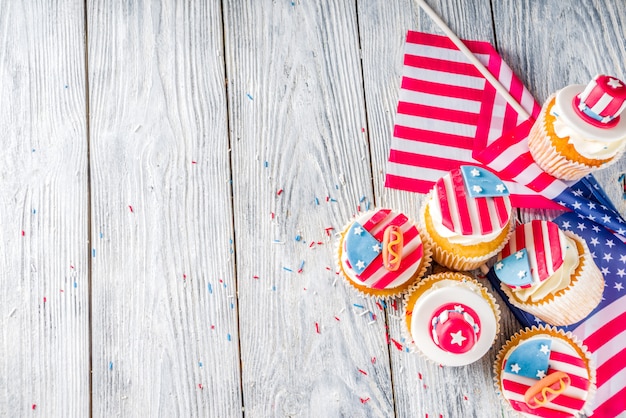 Patriotic USA cupcakes over flags on wood table