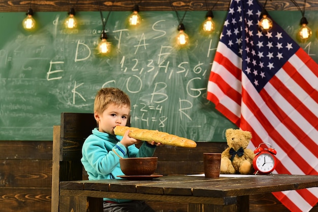 Patriotism and freedom little boy eat bread at american flag at
knowledge day school kid at lesson in 4th of july happy
independence day of the usa back to school or home schooling