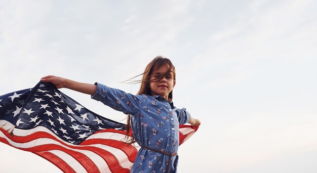 Patriottisch vrouwelijk kind met Amerikaanse vlag in handen