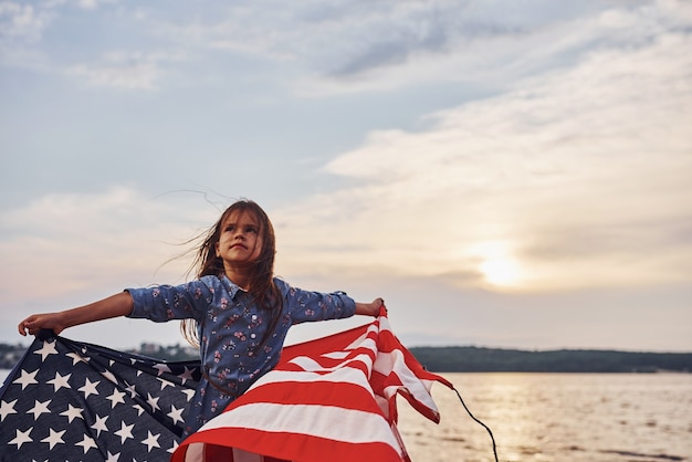Patriottisch vrouwelijk kind met Amerikaanse vlag in handen