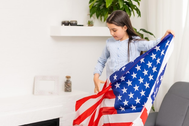 Patriottische vakantie. Gelukkig kind, schattig klein kind meisje met Amerikaanse vlag. VS vieren 4 juli.