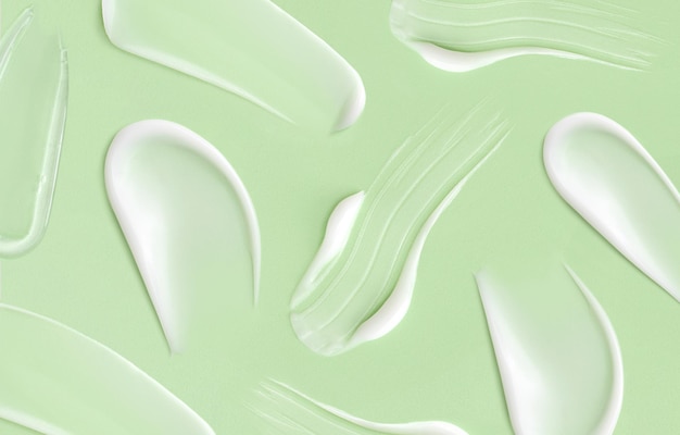 Patroon cosmetische uitstrijkjes crème textuur op pastel groene achtergrond