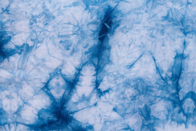 Patroon van blauwe das batik kleurstof op katoen doek, Gekleurde indigo stof achtergrond en getextureerd, Geschilderde blauwe aquarel op witte katoenen doek