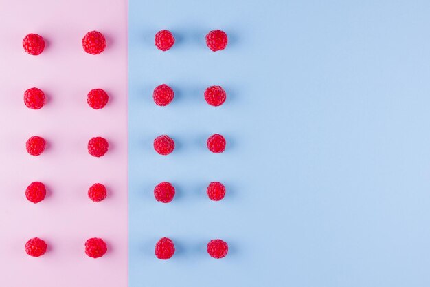 Patroon van frambozen op roze blauwe achtergrond Kleurrijk dieet en gezond voedingsconcept