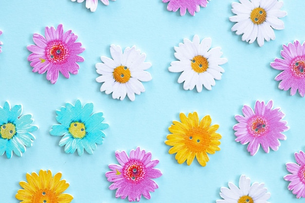 Patroon van houten gekleurde bloemen op blauwe achtergrond