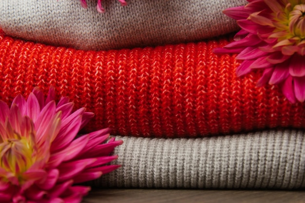 Patroon van kleurrijke gebreide truien close-up handgemaakt product van merinowol een stapel gevouwen kleding met bloemen
